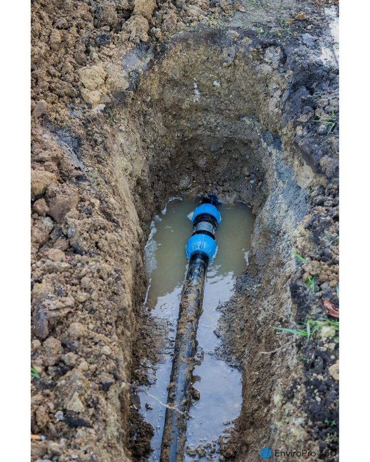 Underground pipe leak — black pipe with blue fitting in trench
